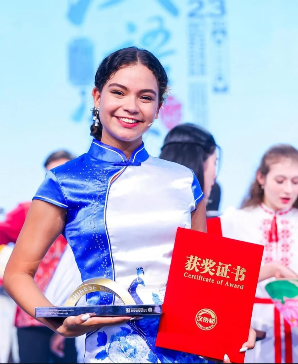 Joven venezolana sostiene el trofeo del concurso Puente Chino (Chinese Bridge).